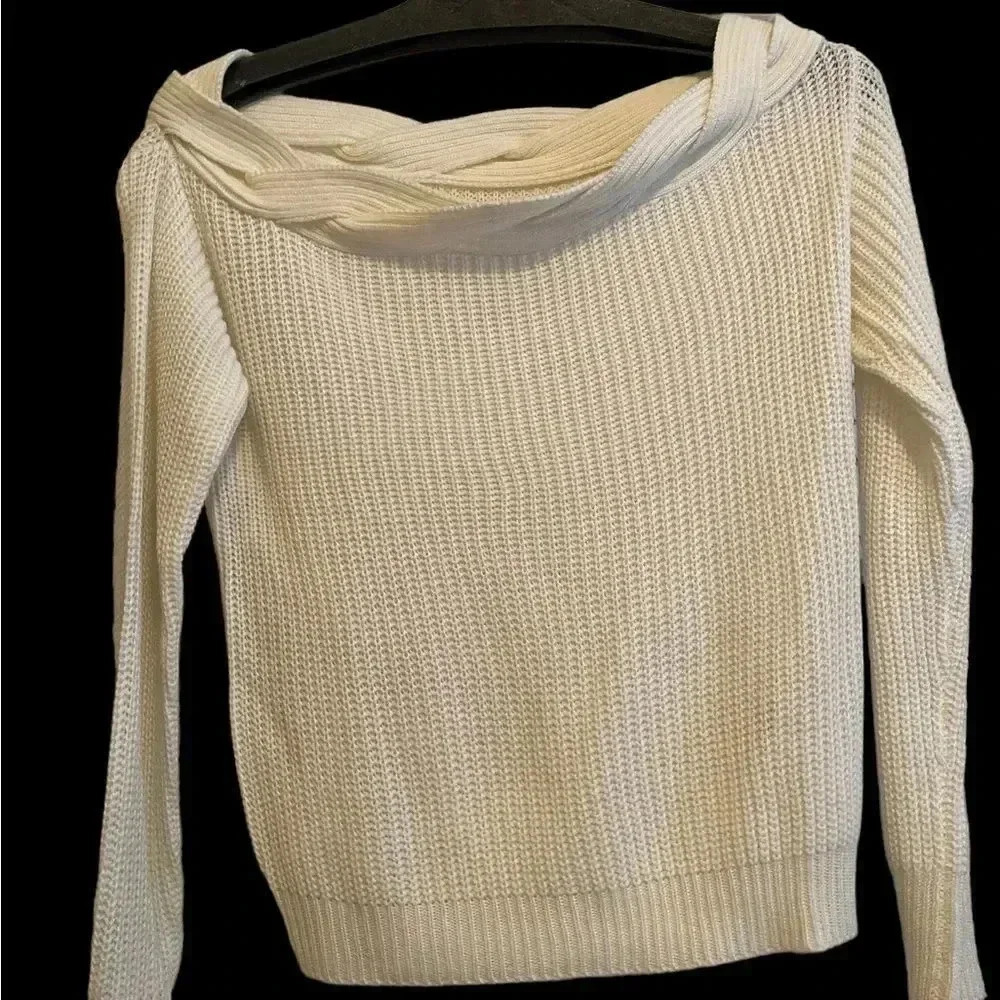 Off the shoulder cream sweater with braided neckline.